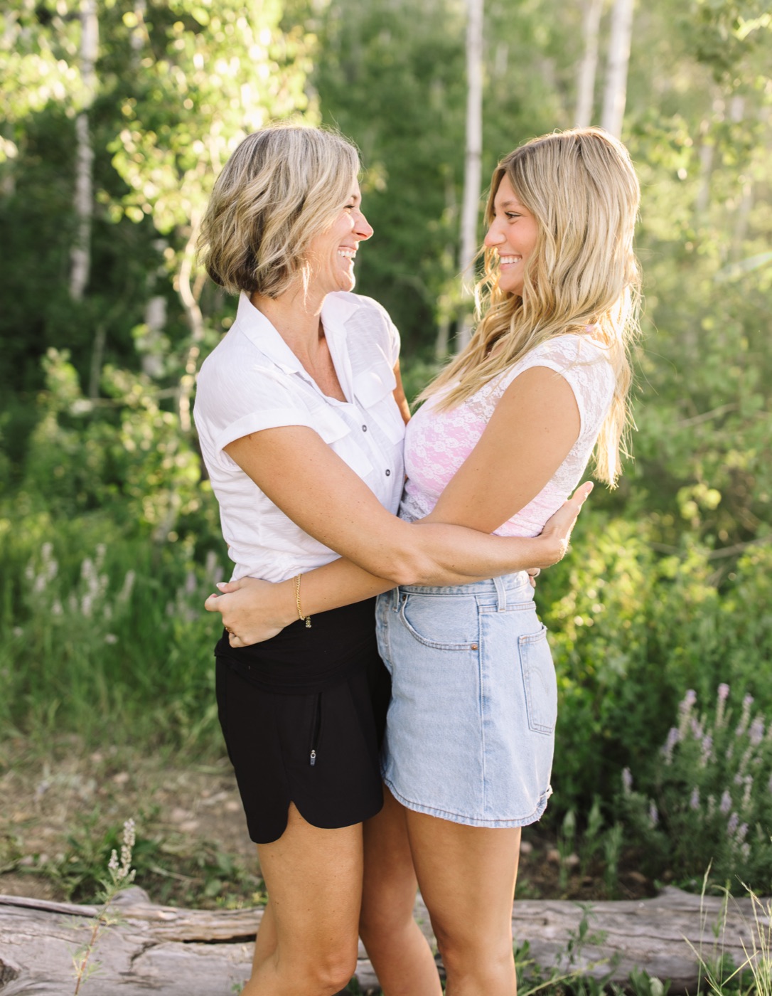 Niki and Harper laughing together among aspen trees